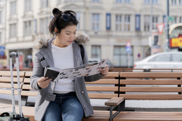 维也纳旅游亚洲女性女性坐在公共长椅上放松地查看城市地图，以快乐无忧无虑的感觉制定旅行计划路线，亚洲女孩享受奥地利维也纳之旅图片下载