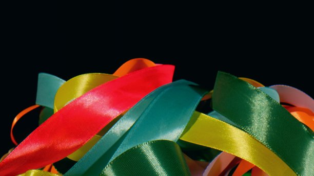 大量的丝绸扭曲的彩色明亮的丝带-接近图片下载