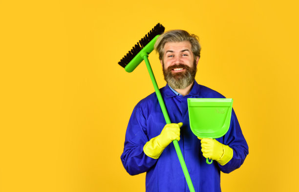 春季大扫除。清洁服务人员。成熟的男性工人用扫帚打扫。男清洁工用扫帚打扫。男人用扫帚打扫家。清洁工在扫地。本空间图片下载