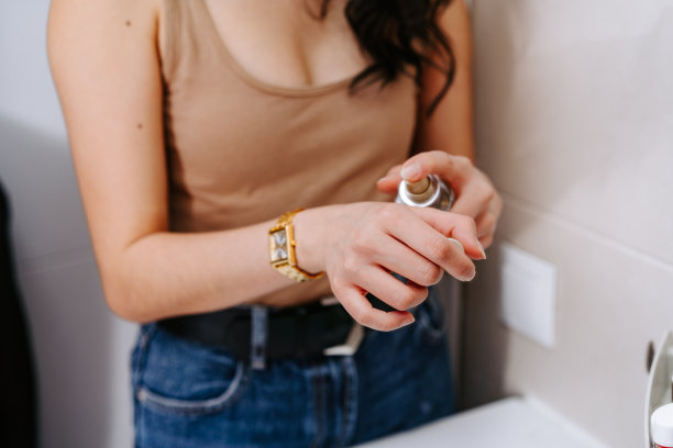 头部特写微笑的亚洲年轻女子使用化妆品刷，看着镜子，美丽的女孩把日常化妆，应用粉末，淋浴后站在浴室图片下载