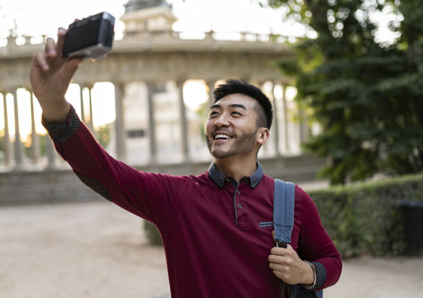 快乐的亚洲游客在公园自拍图片下载