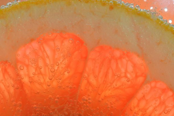 红葡萄柚片的特写。柚子切片的质地。微距水平图像。创作的背景图片下载