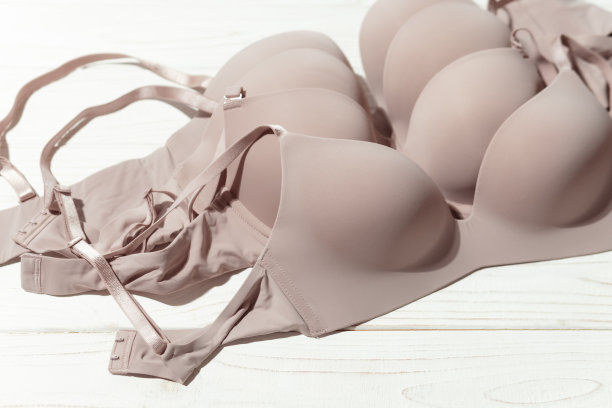 一套米色胸罩在木制背景，特写。图片下载