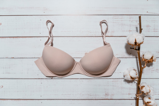 粉红色胸罩与白色木制背景的棉花早午餐，特写图片下载