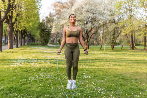 快乐的年轻黑人女运动员全长跳绳在城市公园锻炼，自由空间图片下载