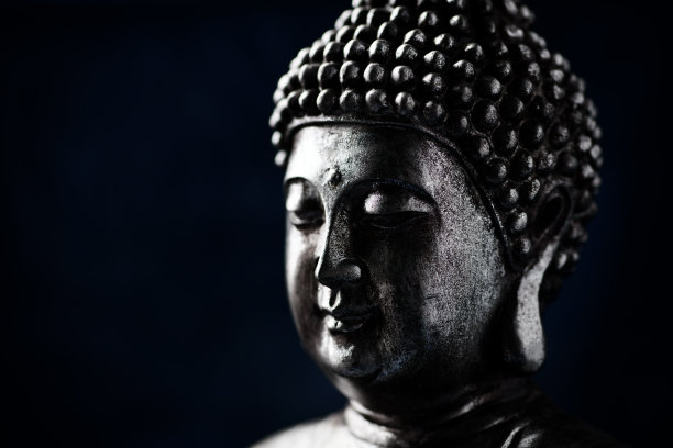 在黑暗背景上冥想的佛像。软的焦点。关闭了。副本的空间。图片下载