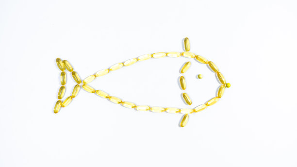 鱼，由黄色透明鱼油胶囊制成，欧米茄3。白色背景。图片下载