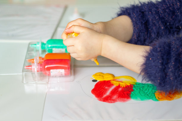 一个小孩的双手在绘画创作活动。快乐的小女孩用颜色画画。 孩子们在学校或家里的创造性爱好图片下载