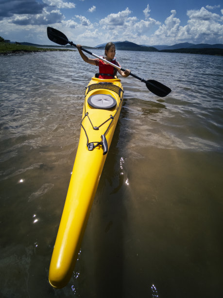 皮划艇和生态旅游。女子在山湖中划水。图片下载