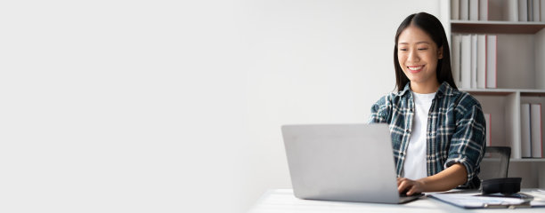 有创意的年轻女性在她的工作室里用笔记本电脑工作。图片下载