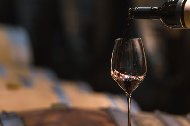 双手把红酒从瓶子里倒进杯子里图片下载