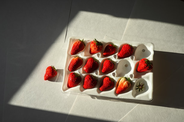 甜甜的浆果装在包里，是礼物。白色绝缘包装的草莓。图片下载