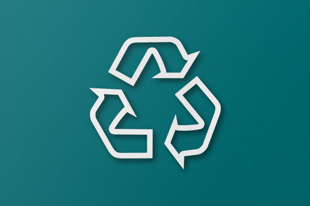 白纸被切割成可回收的形状，孤立在绿色纸背景上。图片下载