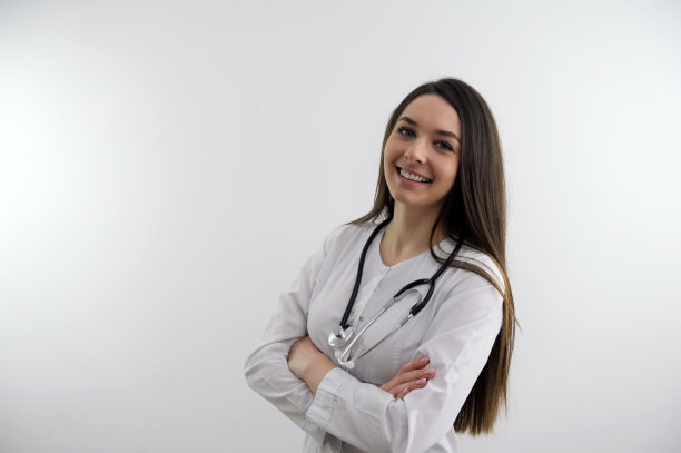 看那边，美丽的白人女医生站在灰色的背景上，指着一边对你微笑。图片下载