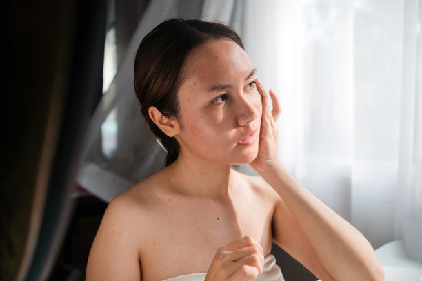 居家美容概念，亚洲女性在脸上涂抹护肤霜。图片下载