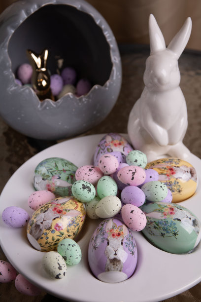 照片上明亮的装饰大大小小的鸡蛋躺在一个特殊的盘子里，旁边有一只小白兔放在圆形玻璃桌上图片下载