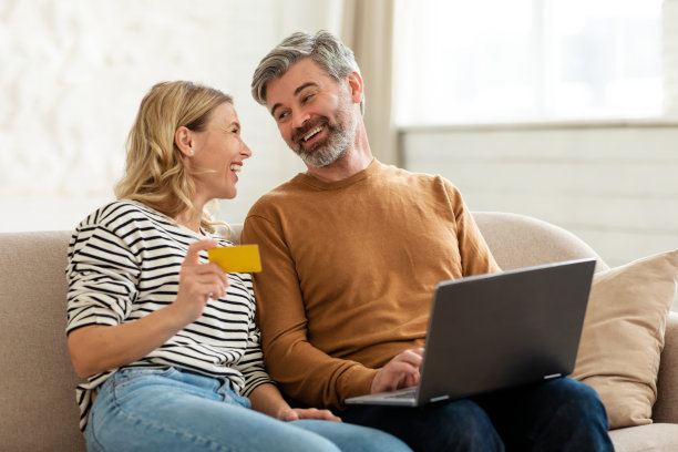 幸福的情侣在室内使用笔记本电脑和信用卡网购图片下载