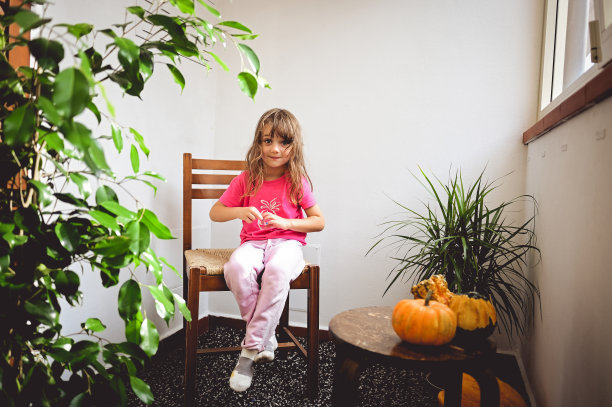 可爱的微笑女孩在阳台上休息，享受阳光。图片下载