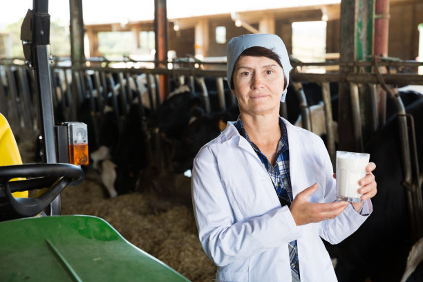 高级女兽医在奶牛场与牛奶图片下载