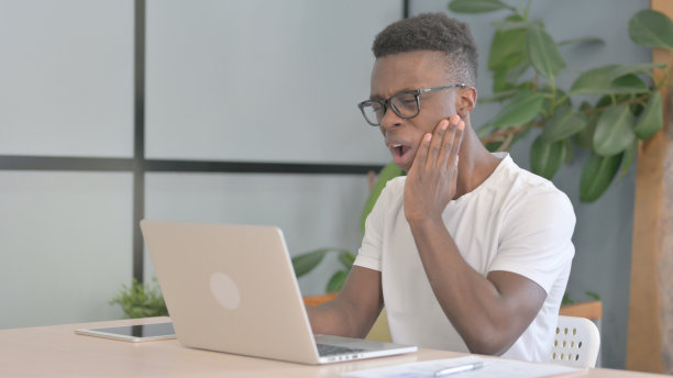 年轻的非洲男子工作时牙痛图片下载