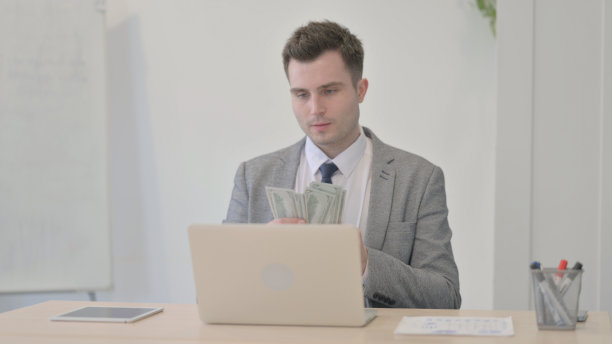 年轻的商人在工作时把钱扔到空中，美元图片下载