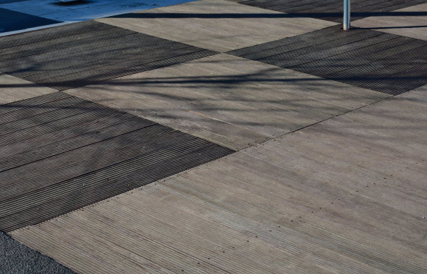 办公室的木地板由热带木材制成，经过时间的推移逐渐变成灰色。压力浸渍，从短角度的碎片堆叠在一起，像拼花。沿着路面呈拱形，几何形状，很正式图片下载