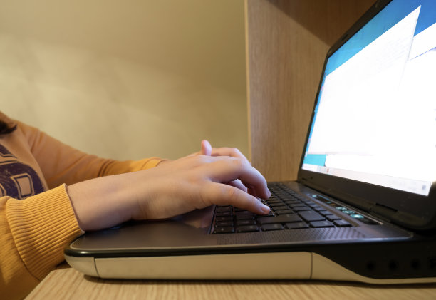 在家中键盘上打字的少女，家庭学校概念图片下载