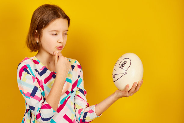 快乐顽皮的少年女孩抱着滑稽的鸵鸟蛋图片下载