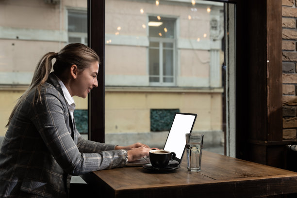 年轻的女商人坐在咖啡店里，在午休时间喝咖啡，在笔记本电脑上工作。自由职业者全球商人为外国公司的新项目工作图片下载