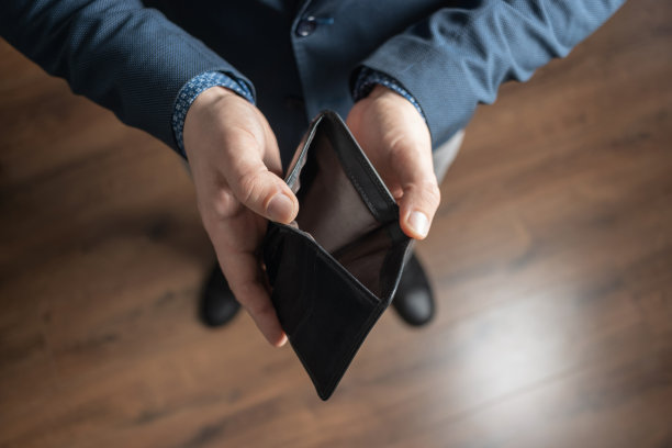 穿着讲究的男人拿着空皮夹。金融危机和破产概念图片下载