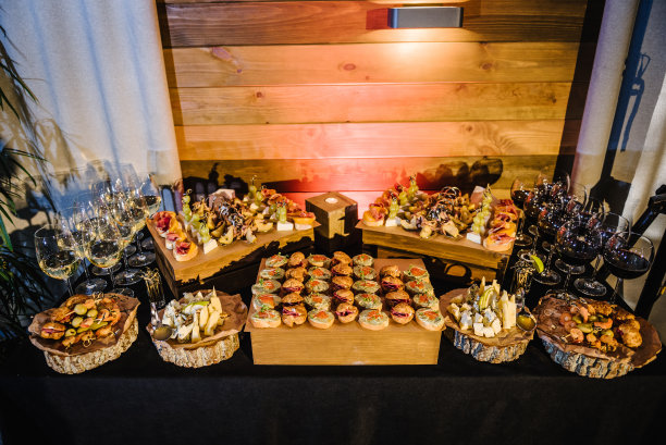 自助餐桌上。黑色餐桌上备有小型冷食、小食和开胃酒。木盘上的食物，节日餐桌上的服务板，公司的食物。派对和假期都没了。图片下载