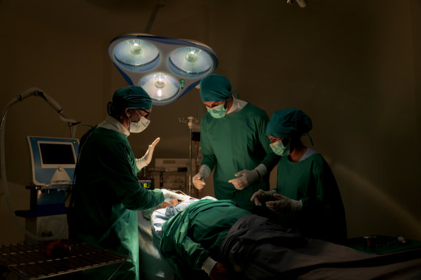 手术室里穿着绿色制服的队医正在抢救正在做心脏手术的危重病人他们有标准化的手术工具救生工具比如心脏泵图片下载