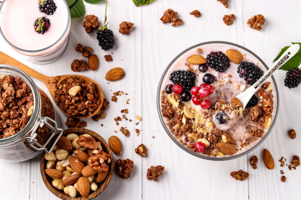 格兰诺拉脆脆蜂蜜什锦麦片配天然酸奶、新鲜浆果、巧克力和坚果，碗里浅背景，健康食品，水平朝向，俯视图图片下载
