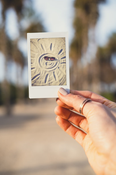 女子在街上拿着即时照片。图片下载