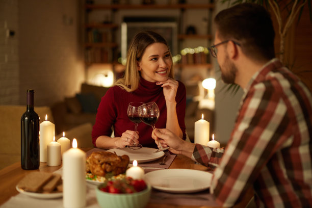 美丽的情侣在家里用蜡烛和红酒共进浪漫的晚餐图片下载