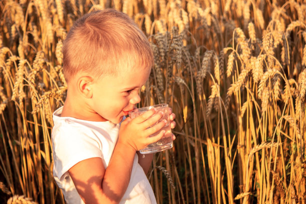 这孩子用玻璃杯喝水。有选择性的重点。图片下载