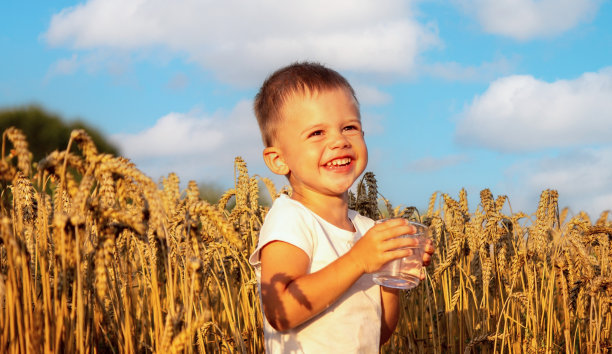 这孩子用玻璃杯喝水。有选择性的重点。图片下载