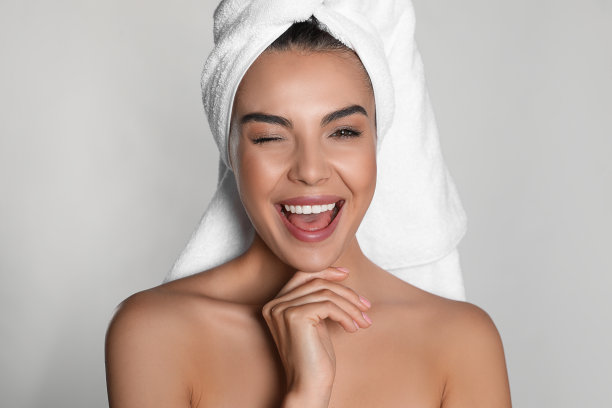 漂亮的年轻女子，头上戴着毛巾，背景很亮图片下载