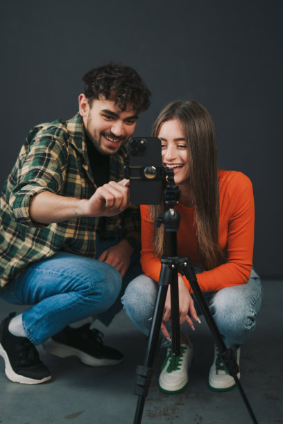 一对年轻男女在三脚架上用手机录制舞蹈挑战视频。z世代的现代生活方式图片下载