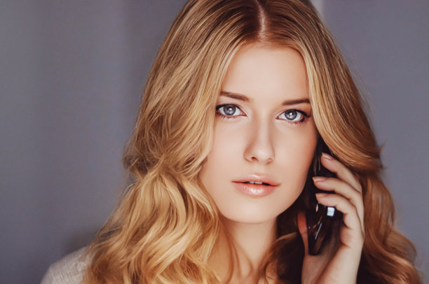 美丽的女人打电话和打电话在手机上图片下载