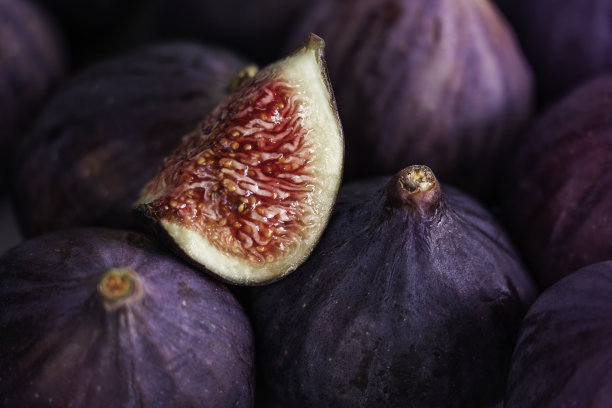 新鲜的无花果片躺在一堆成熟的无花果上图片下载