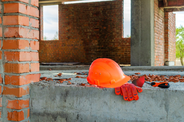 一副手套和一个泥瓦匠头盔。图片下载