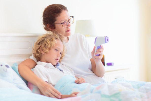 生病的孩子在床上，母亲正在照看生病的孩子图片下载