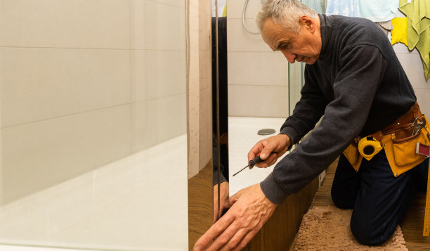 一位老人正在修理淋浴间图片下载