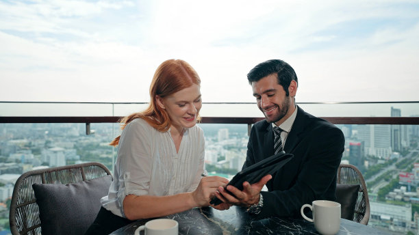 年轻的商人和女人在办公大楼的平板电脑上讨论和签署商业协议图片下载