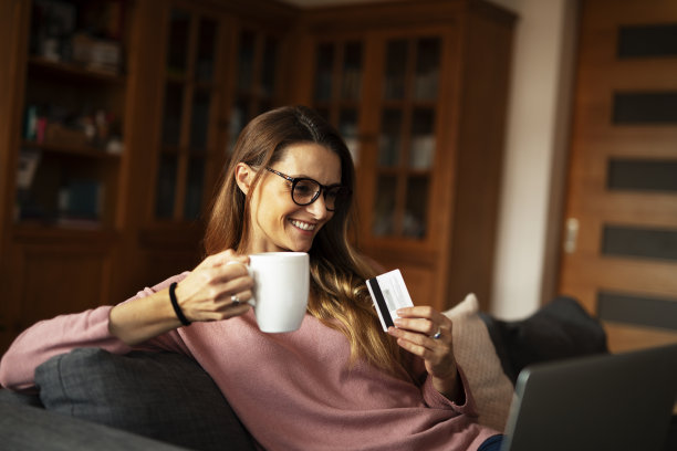 用信用卡用笔记本电脑的美女。图片下载
