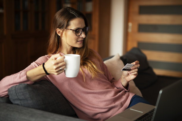 用信用卡用笔记本电脑的美女。图片下载