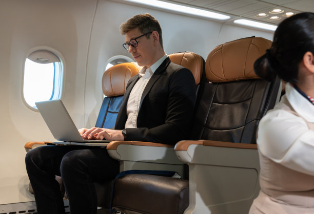 商务人士在飞机上使用笔记本电脑。商务旅行者概念图片下载