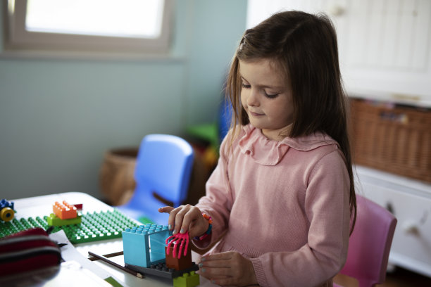 可爱的女孩在家里玩玩具。图片下载