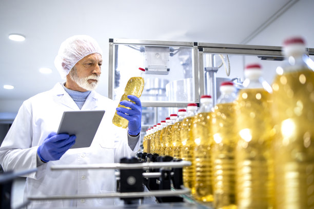 有经验的食品厂高级工人在生产车间内对产品进行目视检查。图片下载